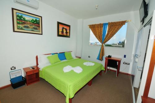 阿约拉港Isla Azul的一间卧室设有一张绿色的床和一个窗户。
