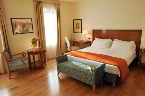 巴索维扎狄彭当斯利帕酒店的配有一张床和一把椅子的酒店客房