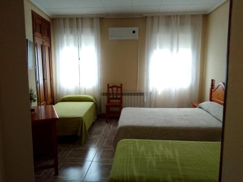 奥卡尼亚Hostal Ávila的酒店客房设有两张床和窗户。