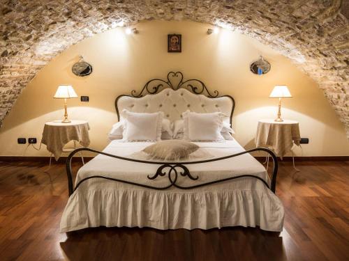 阿西西列托索吉奥纳酒店的一间卧室配有一张大床和两盏灯