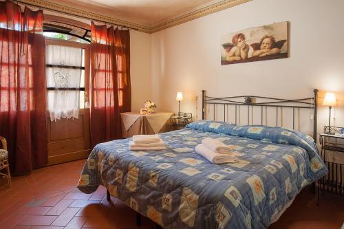 芬奇Agriturismo Il Piastrino的一间卧室配有带毛巾的床