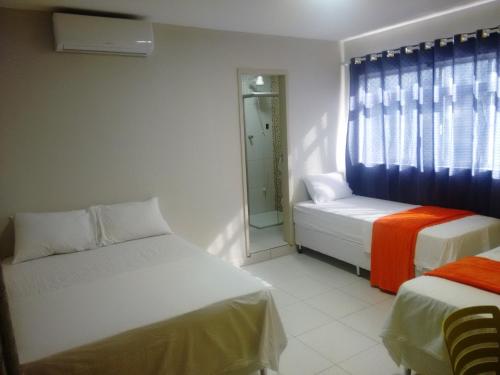 大坎皮纳Pousada Itararé的小房间设有两张床和窗户