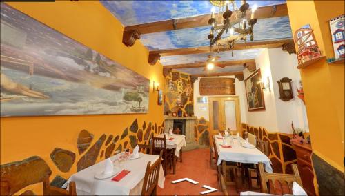 佩德拉希塔Hostal Restaurante Goya的一间在房间内配有桌椅的餐厅