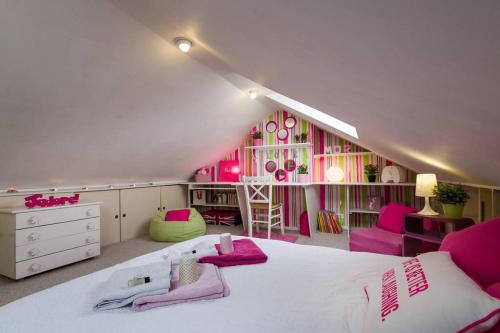 马尔康巴勒尔2 chambres d'hôte proche Lille Gare的一间卧室配有粉色和绿色的家具和一张床