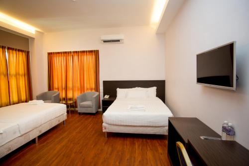拉布安纳闽财富酒店的酒店客房设有两张床和一台平面电视。