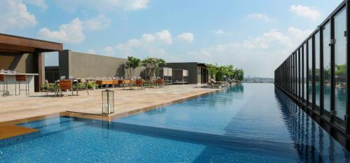 新德里新德里玫瑰色之屋酒店的建筑物一侧的游泳池
