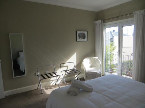 珀斯诺斯伍德住宿加早餐旅馆的一间卧室配有一张床和两把椅子,并设有一个阳台