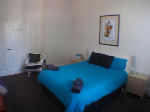 Kingston Beach温莎度假屋的一间卧室配有一张蓝色的床,上面有帽子