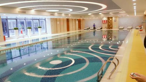 苏州苏州石湖金陵花园酒店的楼里的一个游泳池,地板上有一个迷宫