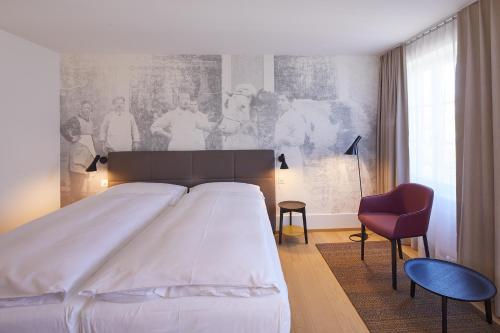 阿尔勒斯海姆奥斯森酒店的卧室配有一张白色大床和红色椅子