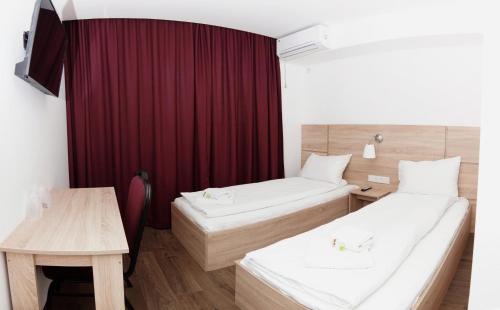 奥托佩尼奥托佩尼潘西乌尼亚酒店的酒店客房设有两张床和一张桌子。
