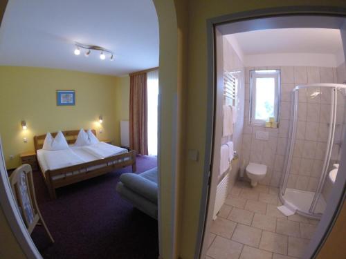巴特拉德克斯堡Gasthof Zum Lindenhof的酒店客房配有一张床和淋浴