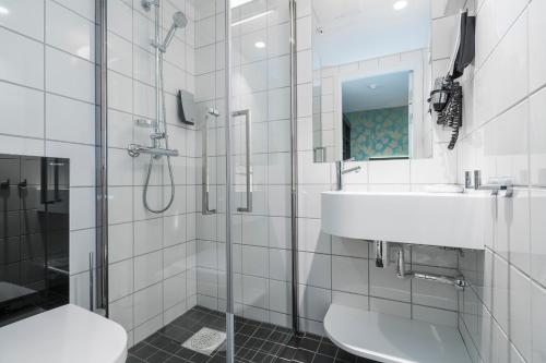 特隆赫姆Thon Hotel Nidaros的白色的浴室设有水槽和淋浴。