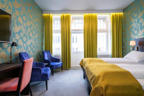 特隆赫姆Thon Hotel Nidaros的酒店客房,配有一张床、一张桌子和椅子