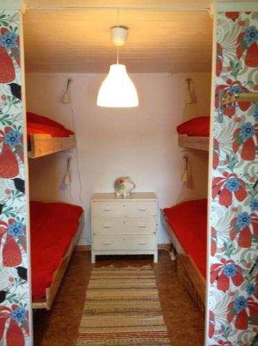 BurträskSvens Stuga的一间卧室配有两张双层床和白色梳妆台