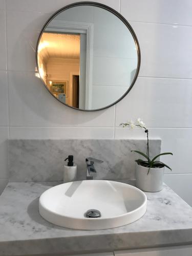Blayney德瑞诗小屋旅馆的浴室水槽和上面的圆镜子