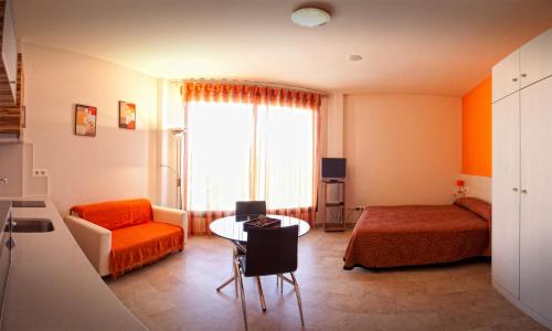 阿尔卡拉拉雷亚尔拉韦德格拉纳达公寓的小房间,配有床和桌子,还有一间房间