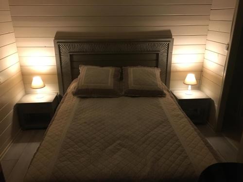 格里莫chalet golfe de st tropez的一间卧室配有一张带两盏灯的床。