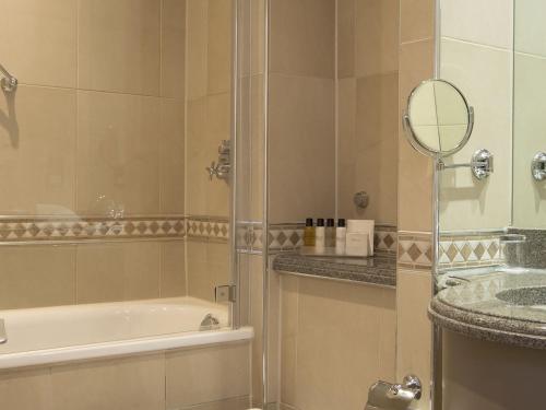 红山努特菲德修道院酒店及Spa的带淋浴、浴缸和镜子的浴室