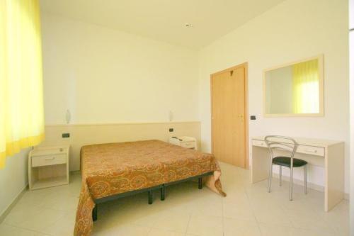 里米尼莎古拉莫拉酒店的一间卧室配有一张床、一张桌子和一把椅子