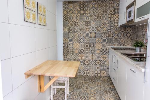 塞辛布拉Filipe Village - Casa da Índia的厨房配有木桌和瓷砖墙。