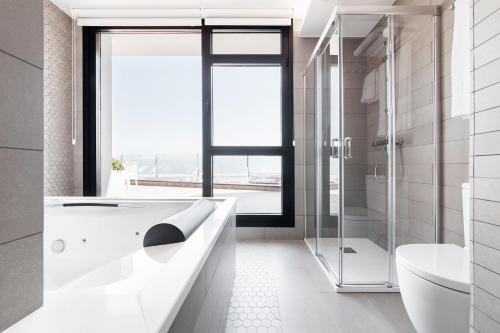 布里拉蒂卡波Apartahotel A Cetárea的白色的浴室设有浴缸和淋浴。