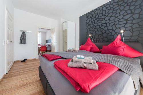 弗莱堡Family-Apartments Freiburg的一间卧室配有一张带红色枕头的大床