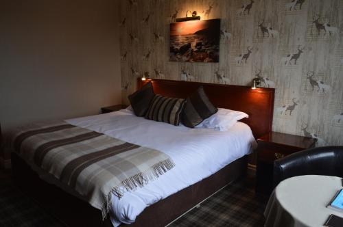 斯卡伯勒Orchard Lodge & Wolds Restaurant的一间卧室配有一张带白色床单的大床