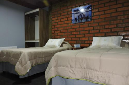 纳塔列斯港Maromava Patagonia的砖墙客房的两张床