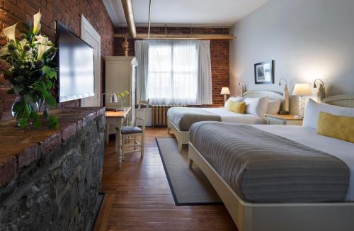 魁北克市Auberge Saint-Pierre的一间酒店客房,设有两张床和电视