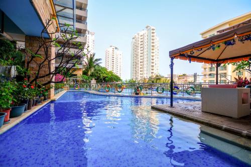 三亚三亚温馨海景公寓的一座建筑物中央的游泳池