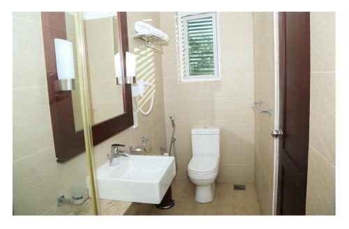 帕西库达Earl's Red Passikudah的一间带卫生间、水槽和镜子的浴室