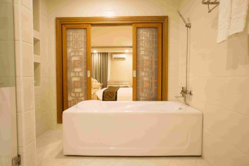 金瓯安努戈耶酒店的浴室设有白色浴缸及镜子