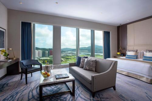 澳门新濠影滙酒店的酒店客房配有床、沙发和桌子。