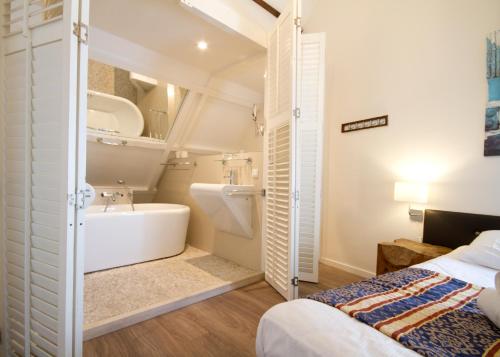 阿姆斯特丹阿科斯塔酒店的一间带床、浴缸和水槽的浴室