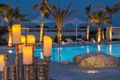 科斯镇White Pearls-Adults Only Luxury Suites的一组蜡烛在游泳池前
