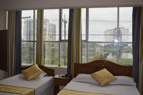 库克斯巴扎Hotel Marine Plaza的带大窗户的客房内的两张床