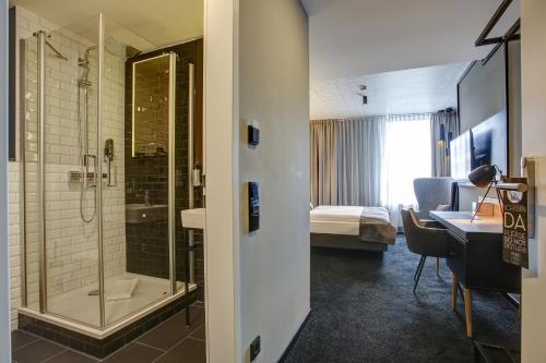 多特蒙德NYCE Hotel Dortmund City的酒店客房设有淋浴和一间卧室。