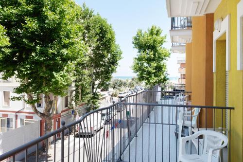里米尼圣皮埃尔酒店的阳台,带椅子和树木的建筑