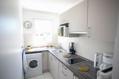 MainvilliersGrain de Blé的白色的厨房配有洗衣机和水槽