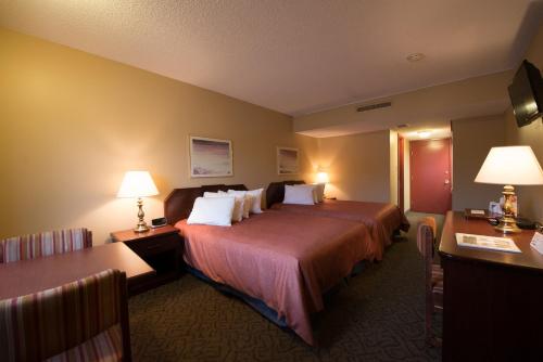 温尼伯阿西尼博因戈登公园酒店的酒店客房,配有一张床、两张桌子和台灯