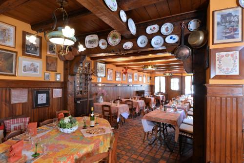 沙特努瓦Hotel Restaurant Dontenville的餐厅墙上设有桌椅和盘子