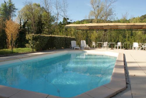 赛尼翁Villa Les Carlets的一个带桌椅的大型游泳池