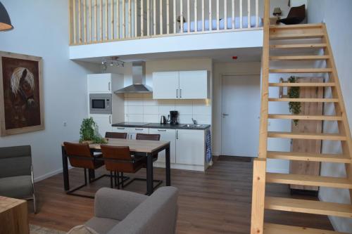 黑泽De Rulse Hoeve的厨房以及带木制楼梯的客厅。