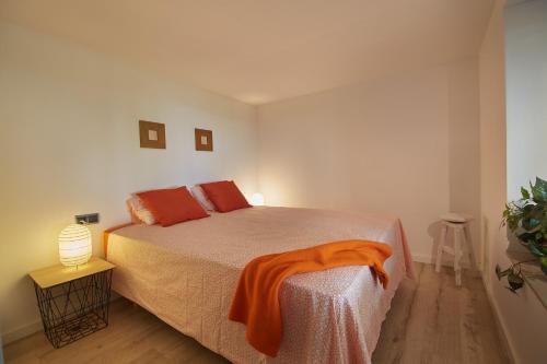 卡夫里尔斯Apartment Pearl of Cabrils的一间卧室配有一张带橙色毯子的床