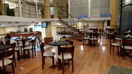 CasildaHotel Cuatro Plazas的一间带桌椅的餐厅,以及楼梯