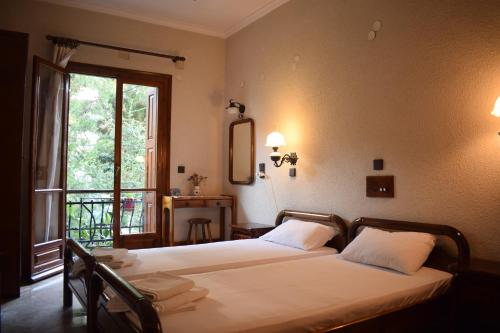 毕达哥利翁Pension Felippe的一间卧室设有两张床,窗户设有阳台