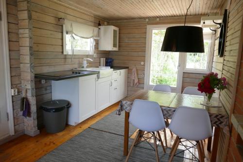 MuratsiTinore Holiday Home的厨房配有桌子和一些白色的椅子
