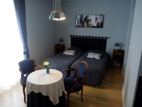 谢尔河畔努瓦耶乐克洛斯切尔酒店的一间卧室配有一张床和一张桌子及椅子