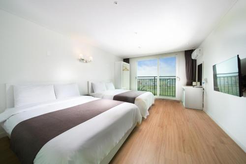 济州市阿莫里克度假村的酒店客房设有两张床和大窗户。